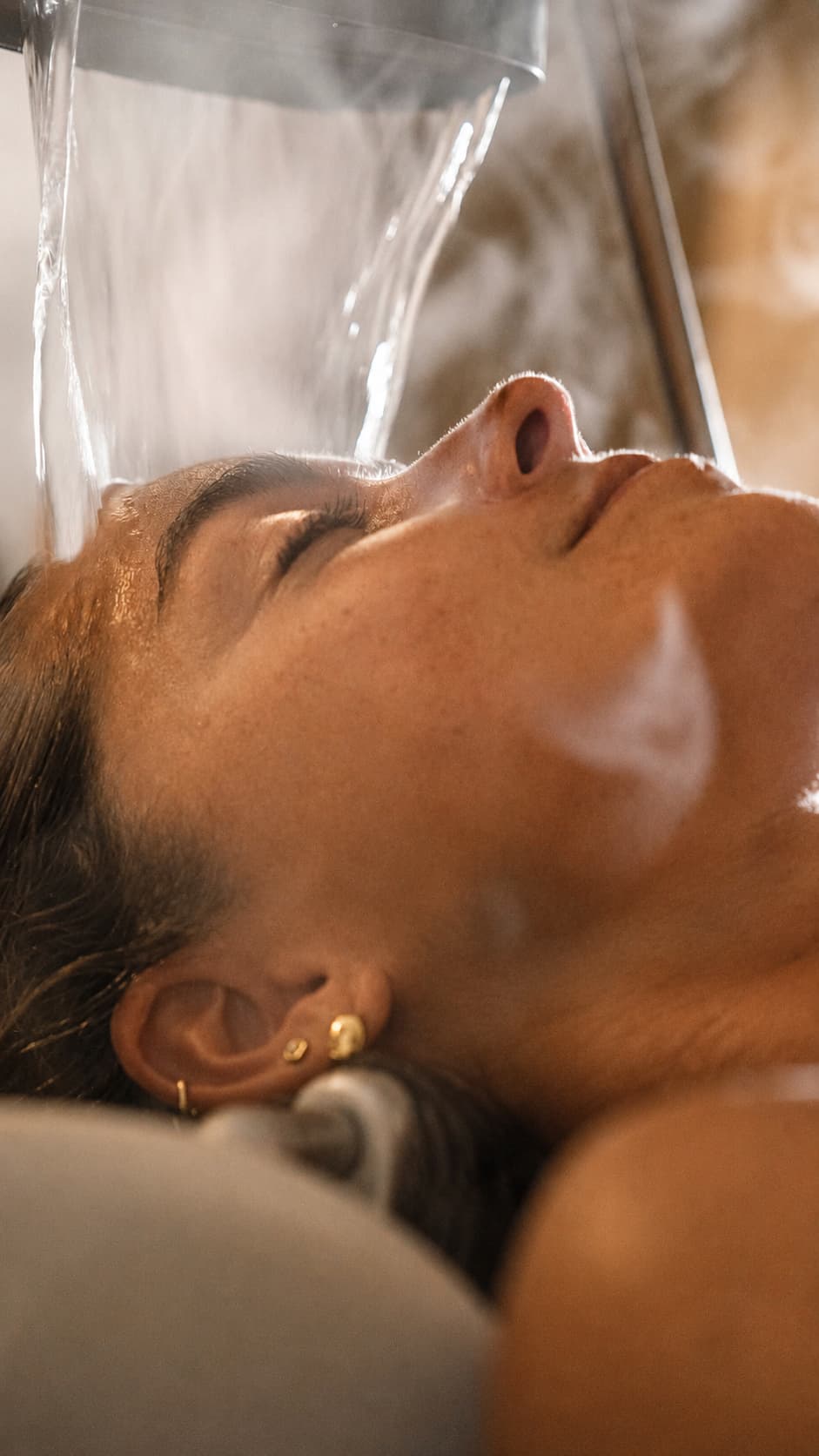 Warm water poured over a guest's head during a La Vela head spa treatment